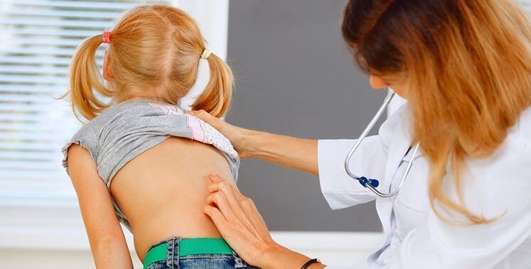 a doctor examines a child's back for low back pain